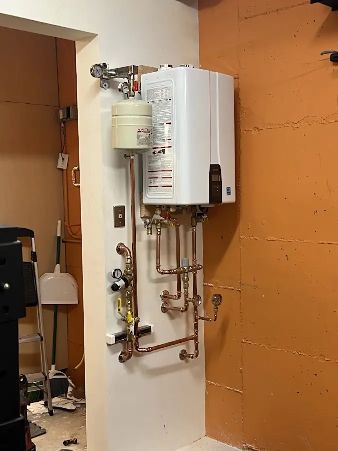 Plumbing technician inspecting water heater connections in Shawangunk